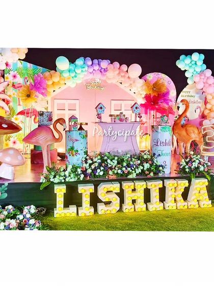 Let's Flamingle! This tropical flamingo party for Lishika's third birthday was full of bright colors and fun props. The stage featured a pink house backdrop, flamingo and mushroom cutouts, and a light-up name sign.