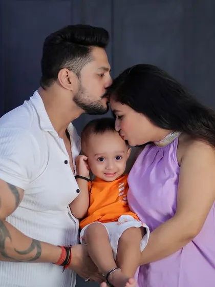 A beautiful, intimate moment between parents and their baby. The double kiss on the baby's head is a gesture of immense love and affection.