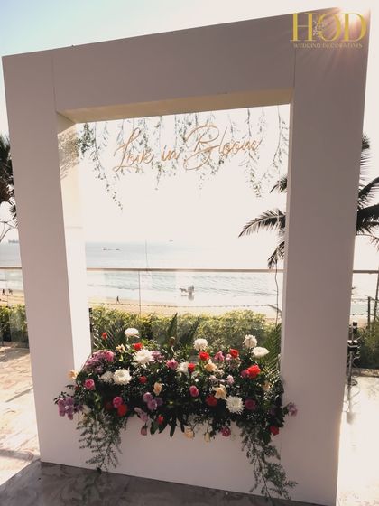 A "Love in Bloom" photo booth perfectly positioned to capture the ocean in the background, creating a romantic and picturesque spot for photos.