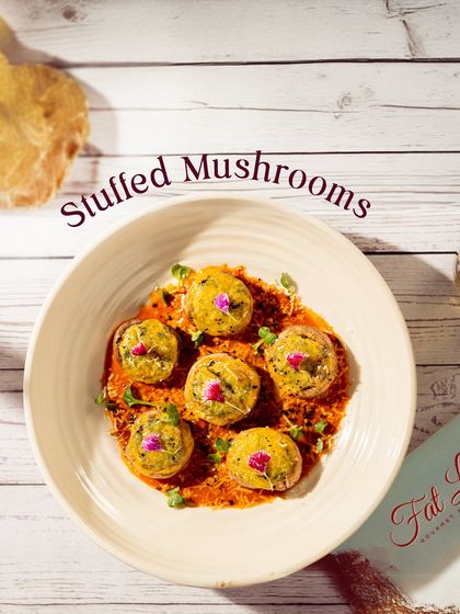 Our Stuffed Mushrooms are a flavor-packed appetizer. Each mushroom is filled with a savory mixture and baked until golden, served on a bed of delicious sauce.