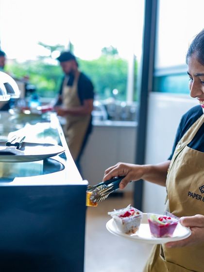 One of our team members happily plating some of our colorful mini-desserts. We take joy in preparing your food.