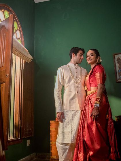 An elegant indoor portrait of a couple, using the rich green walls and antique furniture of our suites as a backdrop.