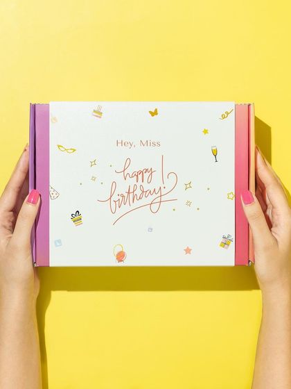 A simple and effective shot that highlights the gift box. Using a hand model and a bright, solid-color background keeps the focus entirely on the beautiful packaging.