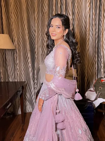 A full-length shot of Anu in her beautiful pastel lehenga. The soft curls and minimal accessories complete this elegant and modern engagement look.