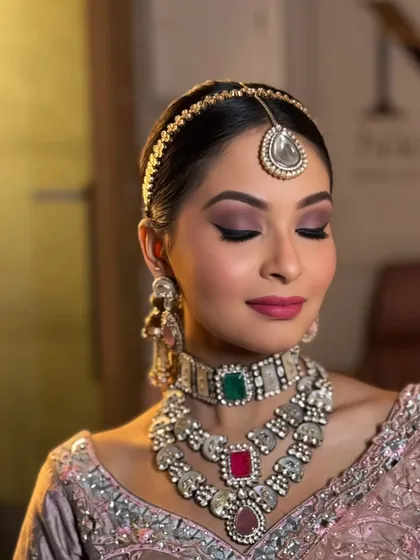 A close-up of a glamorous makeup look, featuring a perfectly blended smokey eye and a soft pink lip.