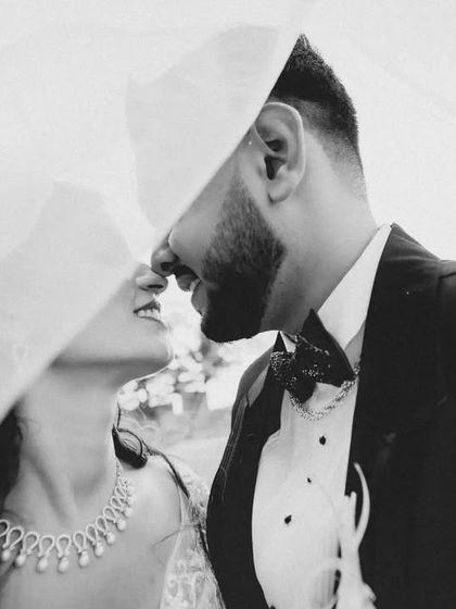 An artistic take on the under-the-veil kiss, with a more abstract composition. This black and white shot plays with the fabric of the veil to frame the moment.