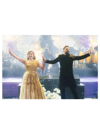 The couple shares a dance on stage, lost in their own world. The live band and sparkling lights create a romantic and lively ambiance for the Sangeet night in Phu Quoc.