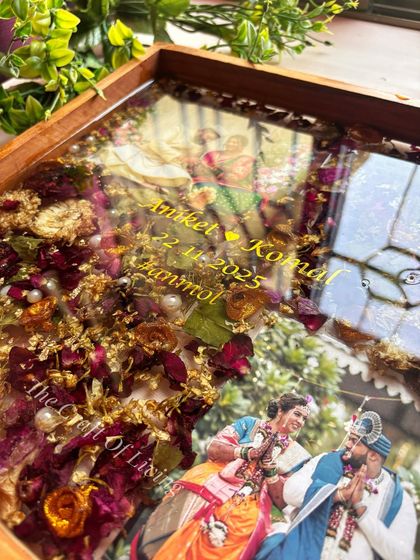 A detailed close-up of the custom text and preserved flowers in the wooden frame. You can see the texture of the petals and the clarity of the resin that protects them.