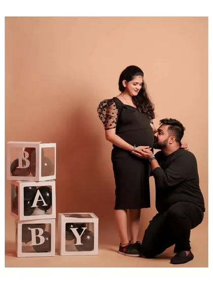 Here's a fun concept for a maternity shoot. The couple chose a coordinated black theme, and we used our 'BABY' block props and a simple beige backdrop to keep the focus on their special moment.