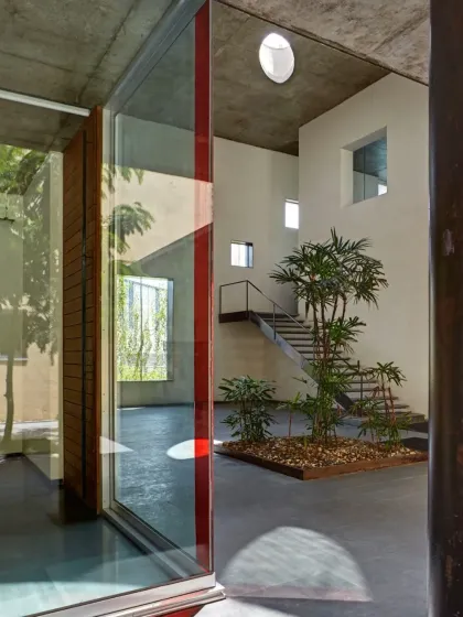 An interior courtyard at the ATE Ahmedabad office brings light, air, and nature deep into the floor plan. The small tree and minimalist design create a focal point of calm within the workspace.