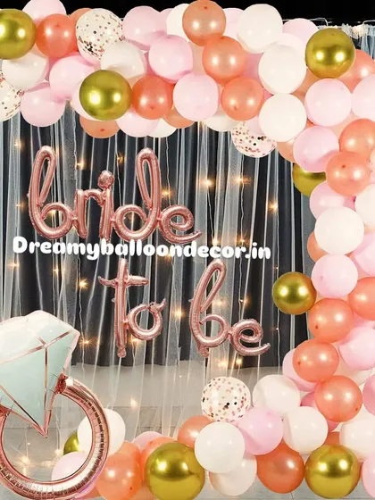 I create stunning, Instagram-worthy backdrops for 'Bride to be' parties. This popular rose gold theme features a full balloon arch with confetti and chrome accents, a shimmery curtain, and a giant diamond ring foil balloon for the perfect photo opportunity.