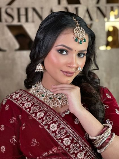 A close-up of the makeup and jewellery paired with the maroon velvet lehenga. The green-beaded kundan set provides a beautiful contrast.