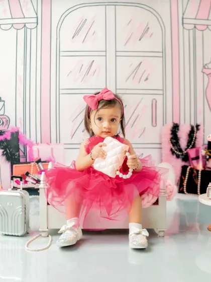 Checking out her stylish pearl-handled purse. The 'Barbie' theme includes many fun, fashion-forward props like mini luggage and designer-inspired boxes to complete the look.