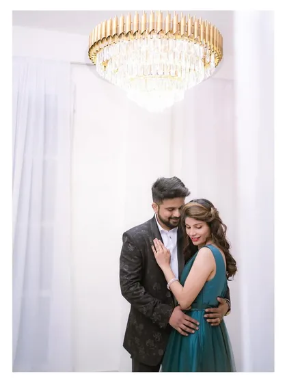 A quiet, romantic portrait under a stunning crystal chandelier. The soft lighting and elegant setting make for a timeless and sophisticated pre-wedding photograph.