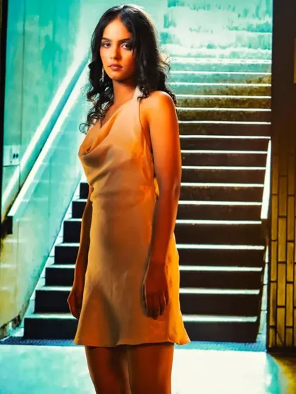 An urban subway station provides a gritty, modern backdrop through projection. The mixed lighting of the scene is used to create a moody and atmospheric portrait.