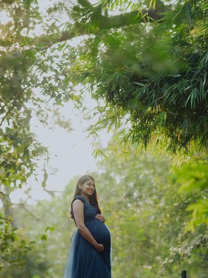 A stunning solo portrait with sunlight filtering through the trees. This shot highlights the beauty of the expectant mother in a serene, sun-dappled environment.