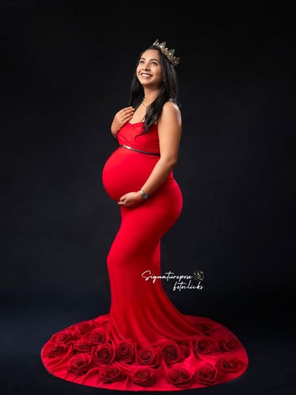 This regal pose with a crown highlights the beautiful silhouette of the mother-to-be against a dark background.