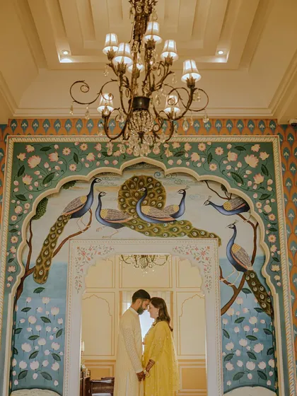 Set against the stunning backdrop of a Jaipur palace, this shot captures a regal and tender moment. The intricate peacock mural and grand architecture add a layer of timeless romance, perfect for couples dreaming of a heritage pre-wedding shoot.