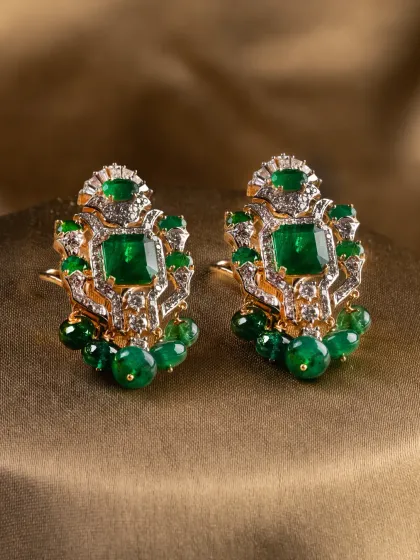 The Aurora Verde earrings, featuring structured emerald and diamond clusters with delicate emerald bead drops.