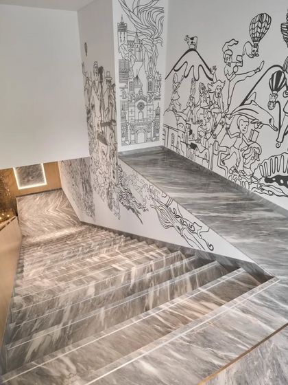 The line-art mural flowing down the staircase, creating a visual journey from land to an underwater world.