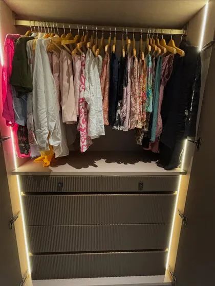 A calm wardrobe starts with a good system. Here, all the clothes are hung on uniform hangers, creating a clean look, while the drawers below hold folded items. It’s about making your space work for you.