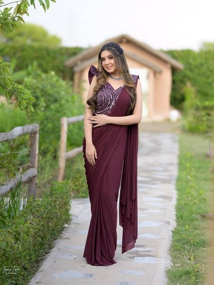 A full-length shot of the draped sari gown. The makeup perfectly complements the modern and chic vibe of the outfit.