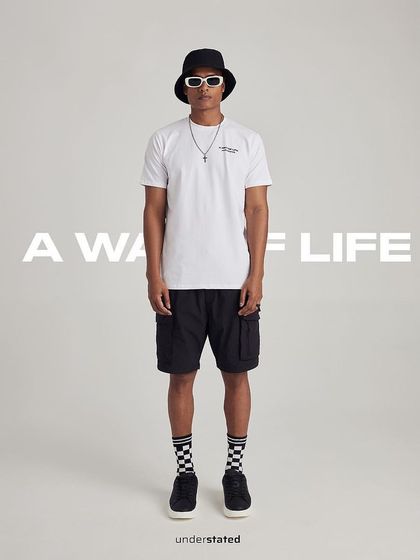A full-body styled look for Understated, combining their t-shirt with shorts and accessories for a complete streetwear outfit.