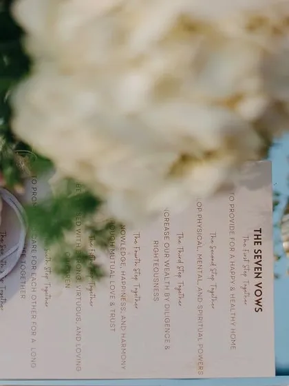 A personalized pouch and a card detailing the 'Seven Vows', placed for guests at the blush wedding. These thoughtful details enhance the ceremony's meaning.