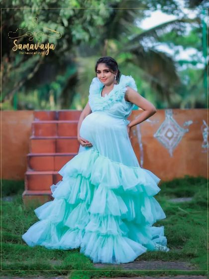 A full-length shot of the pastel blue gown, showing its incredible volume and texture against a simple outdoor background.