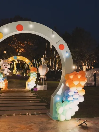 A beautiful lit-up entrance arch for the Looney Tunes party at night.