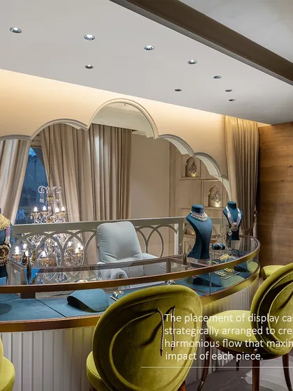 The placement of display cases is strategically arranged to create a harmonious flow and maximize the impact of each piece. This curved counter with olive green chairs offers a comfortable and elegant viewing area for customers.