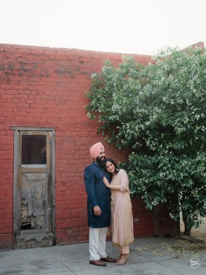 A tender moment against a rustic red brick wall in old Amritsar. We love finding beauty in historic textures and colors to create timeless couple portraits that feel both authentic and artistic.