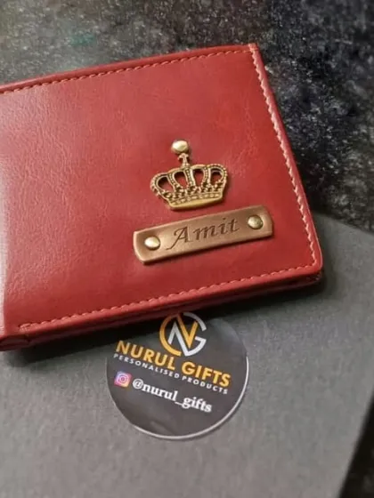 A beautiful red leather wallet customized for 'Amit' with a crown charm, resting on its premium black gift box.