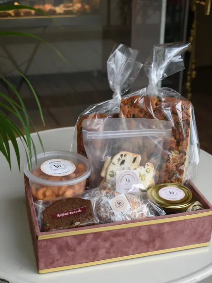 My Christmas hamper is packed with the cozy flavors of the season. This one features a mix of my classic plum cake, assorted cookies, chocolate-coated nuts, and other festive treats, making it the perfect gift for colleagues or loved ones.