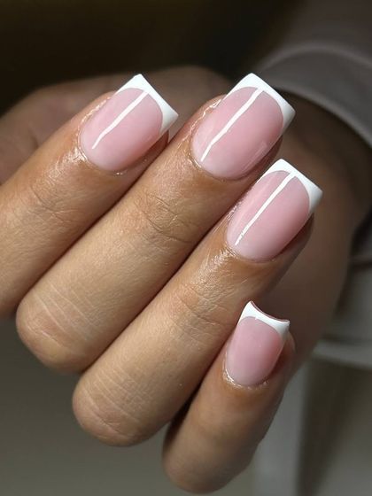 A sharp and modern take on the French manicure. This design features a dramatic, deep 'smile line' and crisp white tips on perfectly sculpted square extensions.