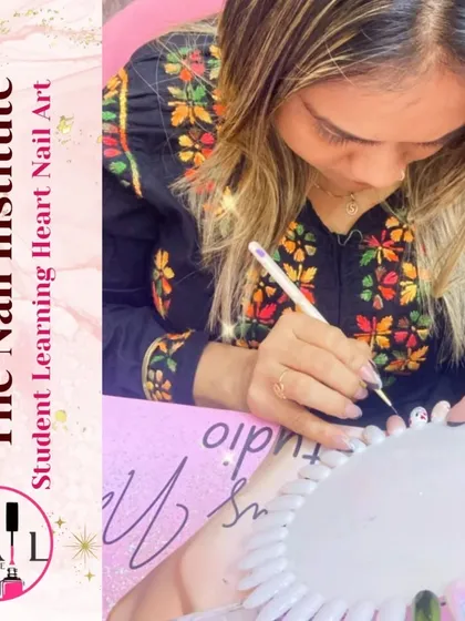 With intense focus, a student practices intricate heart-themed nail art on a practice wheel.