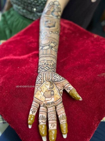 A full view of the arm, showing how the bridal portrait on the palm connects to the rest of the traditional design, creating a cohesive and stunning piece of art.
