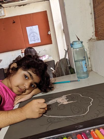 A quiet moment of concentration. Here, a student is carefully outlining her drawing, getting the composition just right before adding color.