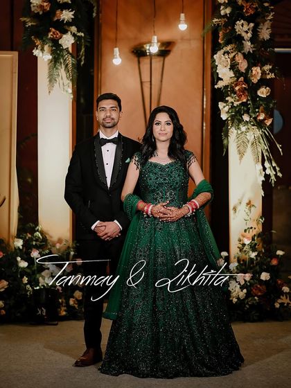 A beautiful reception portrait of the couple. The bride's emerald green gown stands out, and the photo captures the elegance and happiness of their celebration.