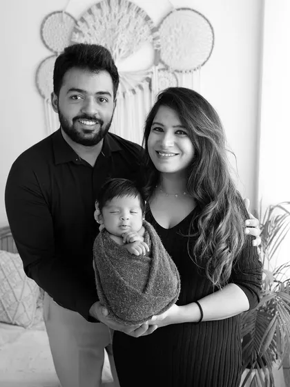 A classic black and white family portrait with a swaddled newborn. This timeless style ensures the photo will be cherished for generations.