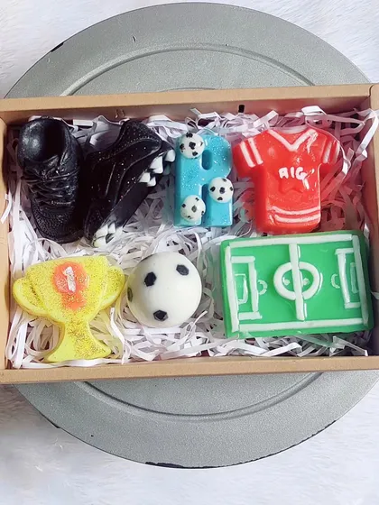 A complete football-themed gift hamper, with soaps shaped like a jersey, shoe, ball, field, and trophy, plus a personalized initial.