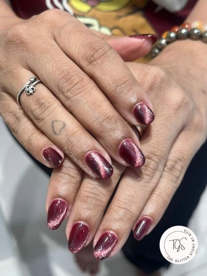 This deep raspberry cat-eye polish has a beautiful pink shimmer that catches the light. It's a great choice for a look that's both dark and vibrant.