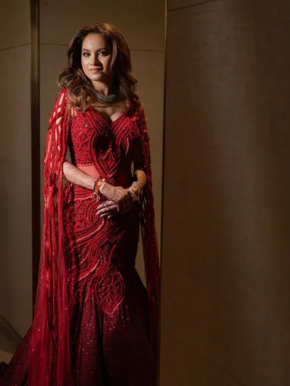 A frontal view of the ruby red embellished lehenga, a silhouette that moves with grace and glows with craftsmanship.