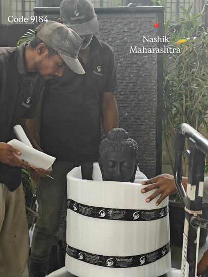 A 3-foot black marble Buddha statue being carefully wrapped in protective foam before being placed in its crate for shipment to Nashik.