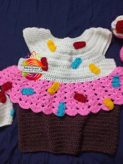 A sweet cupcake-themed dress set, complete with a sprinkle-covered hat and matching pink shoes. This is one of my most requested custom crochet baby outfits, ideal for making any day feel like a celebration.
