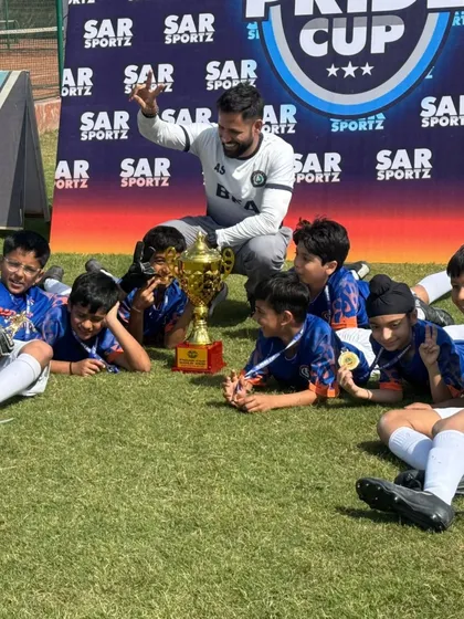 A moment of relaxation and pride after a big win. The team enjoys their victory with the SAR Pride Cup trophy.