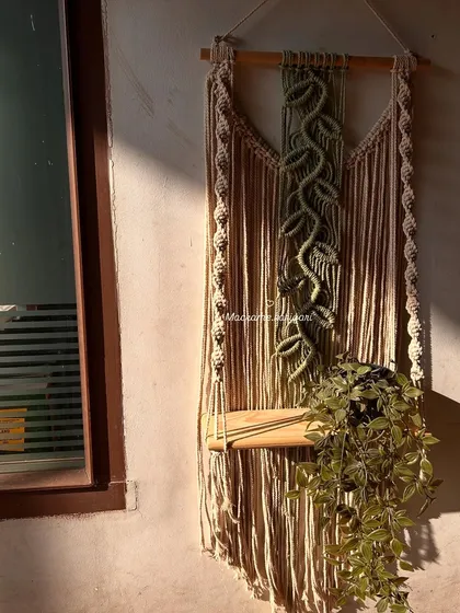 A quiet moment of work, with a macramé plant hanger catching the morning sun. It's in these simple moments that we find the most joy in our craft.