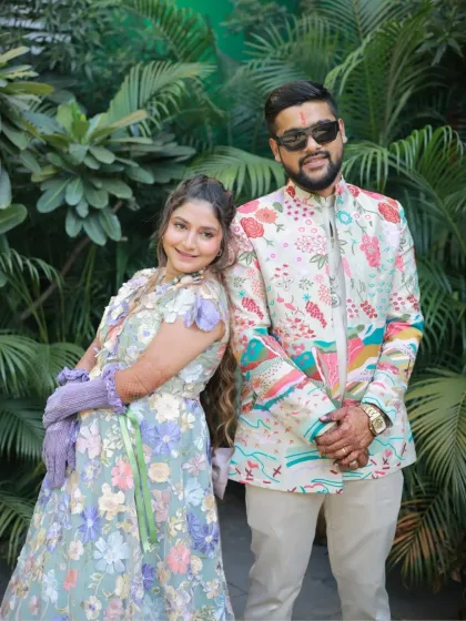 A cool and stylish portrait of the couple. The bride-to-be's makeup is fresh and modern, matching their coordinated floral outfits.