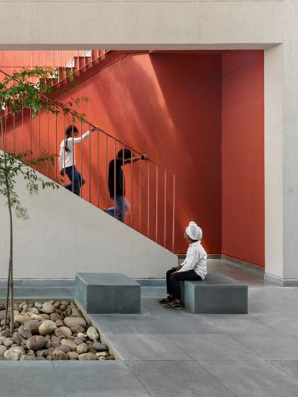 We use color to define spaces and create visual interest. The bright red wall draws you up the stairs and adds a burst of energy to this central courtyard at the St. Martha Bethany Vidyalaya school.