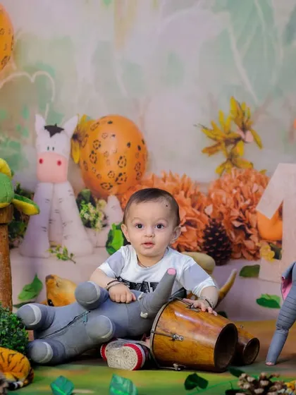This little one is taking a break from exploring to play with his toy elephant and bongo drum in the heart of our studio jungle.
